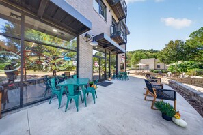 An outdoor patio area with tables and chairs, a glass wall with bicycles, and a view of the surrounding greenery. - Rendezvous Loft · Bunk Studio Above Bike Shop (Bella Vista)