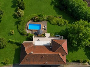 An aerial view of a residential property with a swimming pool, a covered patio area, and a well-maintained lawn. - La Colline Haute, private pool (SAGELAT)