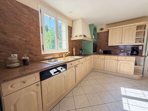 A kitchen with a dishwasher, a window, cabinets, and a microwave. - La Colline Haute, private pool (SAGELAT)