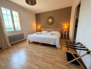 A bedroom with a bed, two bedside tables with lamps, a radiator, a window, and a wall-mounted mirror. - La Colline Haute, private pool (SAGELAT)