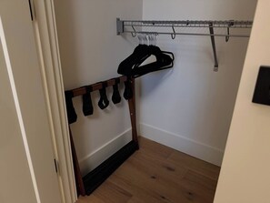 A room with a wooden shoe rack and a metal drying rack against the wall. - The Hidden Cedar | Private Lakefront Escape (Kent)