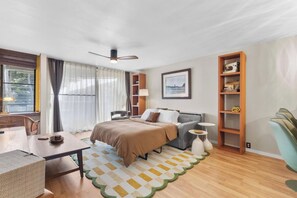 Ein modernes Schlafzimmer mit Bett, Nachttischen, Schreibtisch und Stuhl.