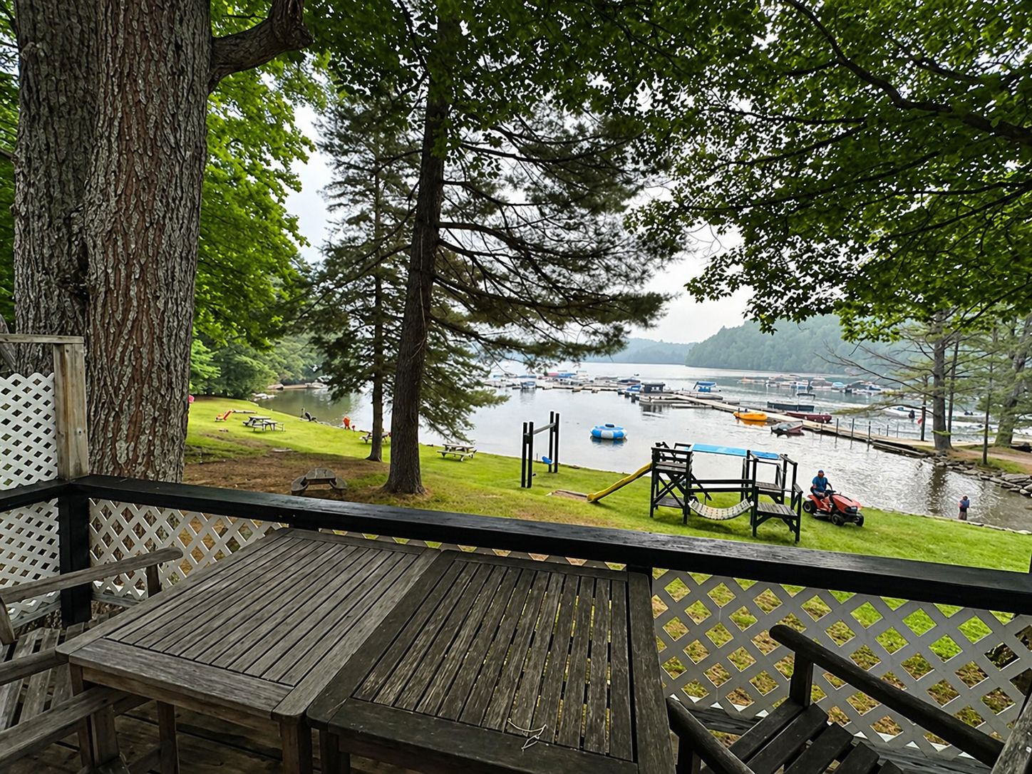 A wooden deck with a view of a lake and boats.