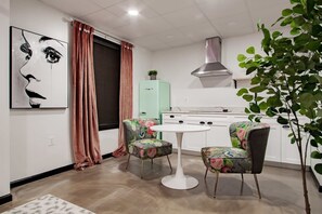 A compact kitchen with a modern stove, a hanging light, and a small cabinet. - Vintage Studio - Walk to the White House (Washington)