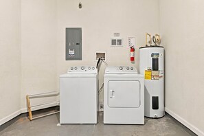 Une buanderie équipée de deux lave-linge à chargement frontal et d’un sèche-linge superposé.