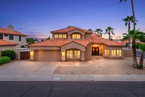 A two-story house with a garage, a driveway, and a well-maintained lawn. - 6Bd Scottsdale Resort Style Escape*Heated Pool/Spa (Scottsdale)
