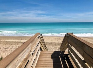 A wooden boardwalk leading to a beach with waves in the background. - Islandia II Cozy Beachfront 2BR Condo, Ocean & River Views, Hutchinson Island FL (Jensen Beach)
