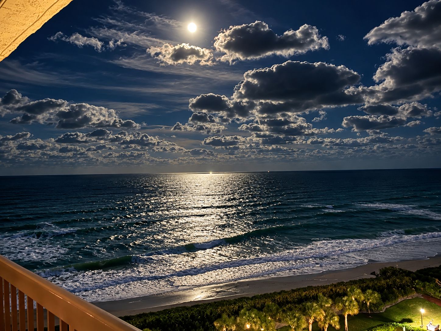 A beach view with ocean waves, a clear sky, and a visible moon.