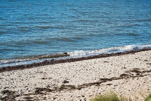 Ein Strand mit klarem, blauem Wasser und einem sandigen Ufer.