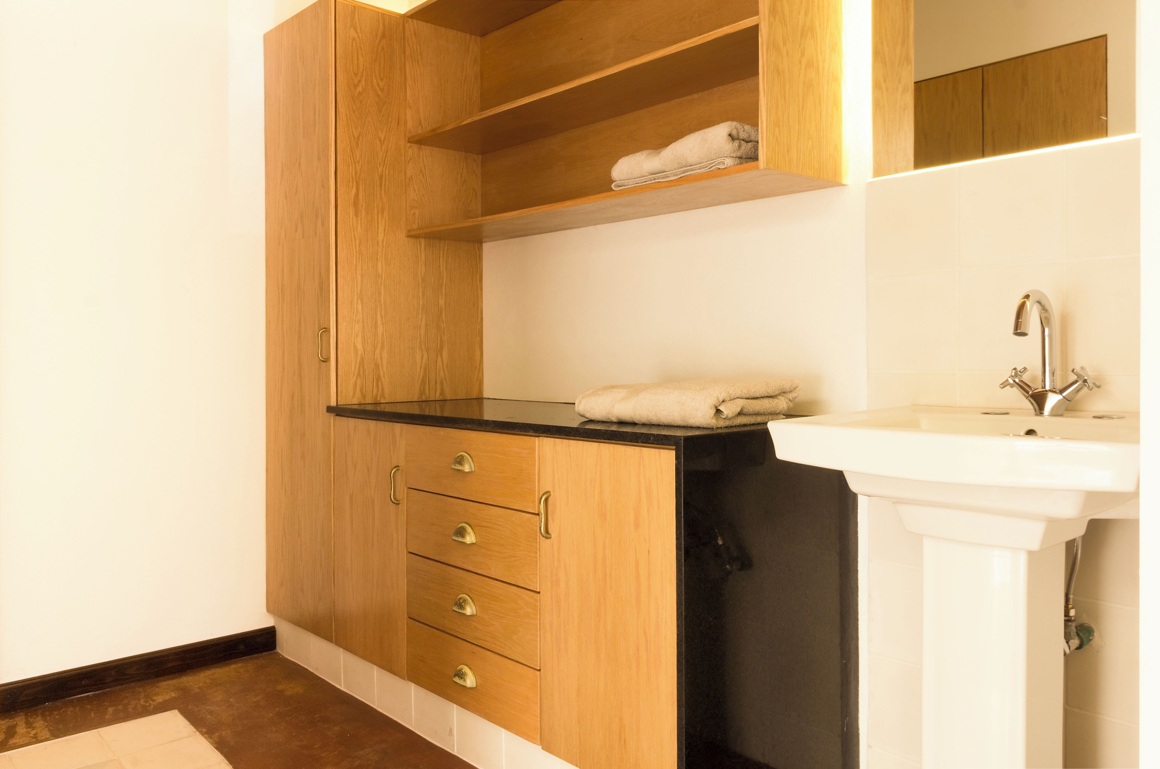 A bathroom with a wooden cabinet, a sink, and a towel on the countertop.