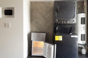 A compact kitchen with a refrigerator, a water dispenser, and a microwave. - 16 de Septiembre by Homi Rent (Santiago de Querétaro)