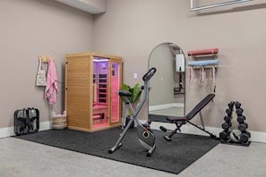 A gym with exercise equipment, a sauna, and a mirror. - Joey's House – Rooftop, Sauna & Karaoke Stage (Nashville)