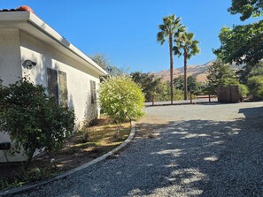 A residential property with a gravel driveway, a white house, and a view of mountains. - Casa Tranquilla in Evergreen, San Jose (San Jose)
