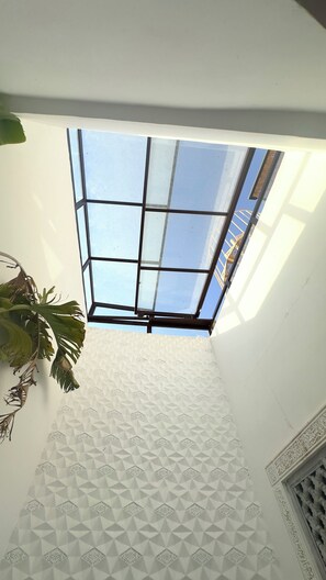 A room with a skylight, geometric wall pattern, and a potted plant. - Fabulous 2-bedroom riad with AC in vibrant Marrakesh (Marrakesh)