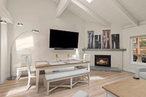 A modern living room with a flat-screen TV, a fireplace, and a dining area. - 16 Mountain Shadows 3BR completely remodeled Incline Village Mtn Views (Incline Village)