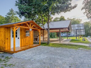Eine Holzhütte mit überdachter Veranda und Picknicktisch.