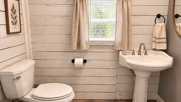 A bathroom with a toilet, sink, and window with curtains.