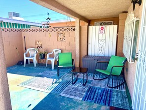 A covered outdoor area with a seating arrangement, a stop sign, and a gated entrance. - The Fremont Studio - 2min from Fremont St! (Las Vegas)