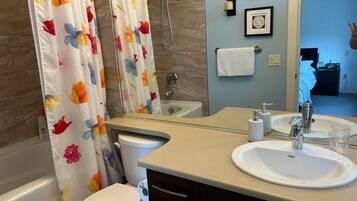 A bathroom with a bathtub, toilet, and sink.