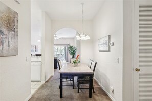 Un espace repas comprenant une table, des chaises et un luminaire suspendu.
