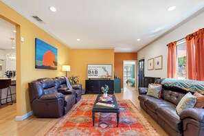 A living room with a sofa set, a coffee table, and a rug. There is a painting on the wall and a sign that reads 'WELCOME HOME'. - Grand Rhapsody  4Bed 2Bath  Huge Yard! (Abilene)