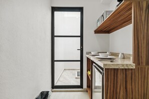 A narrow kitchen with a sliding door leading to an outdoor area.