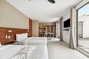 A hotel room with two beds, a dining area, and a TV. - Calesa By Homirent  (Santiago de Querétaro)