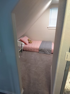 A bedroom with a single bed, a window, and a teddy bear on the bed. - Charming Sanger Home - King Bed & Loft - Sleeps 6 (Sanger)