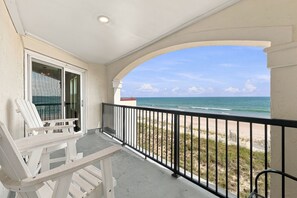 A balcony with a view of the beach, a chair, and a railing. - Ocean Views, Pools Hot Tub & Beach @Villa Capriani (North Topsail Beach)