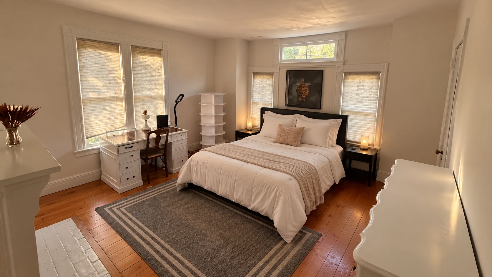 A bedroom with a bed, bedside tables, a desk, and a chair.