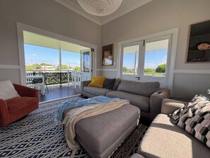 Ein Wohnzimmer mit einer Couch, einem roten Sessel und einem gemusterten Teppich.