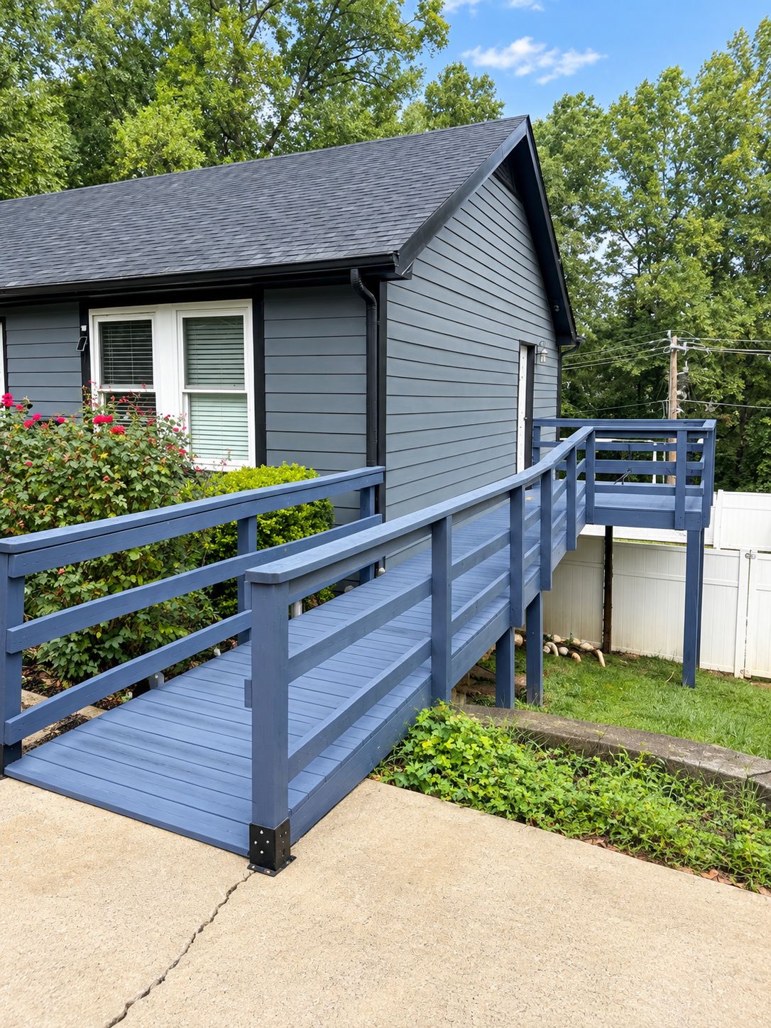 A house with a blue wooden deck leading to a front door.