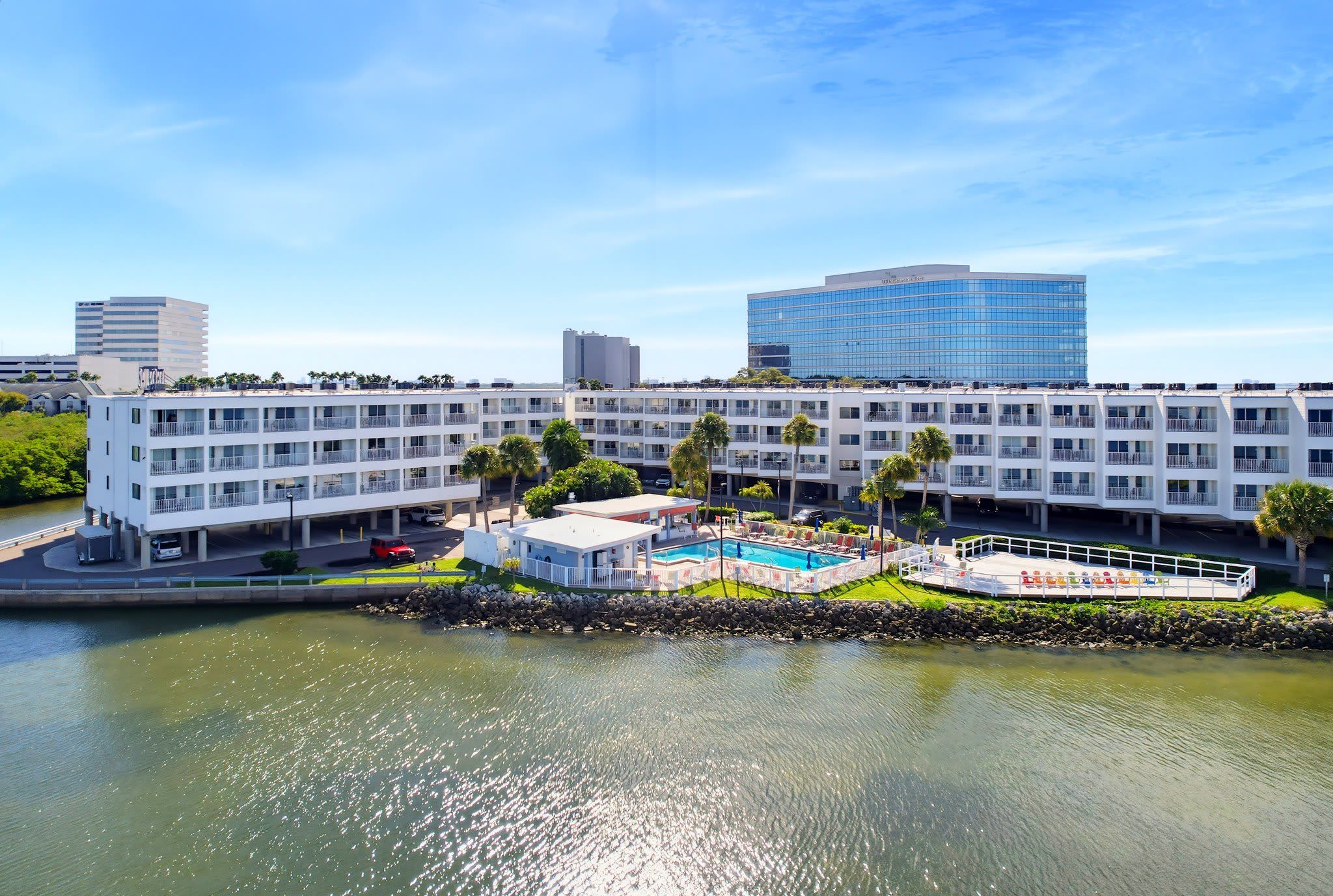 Ett hotell med pool, flera våningar och utsikt över vattnet.