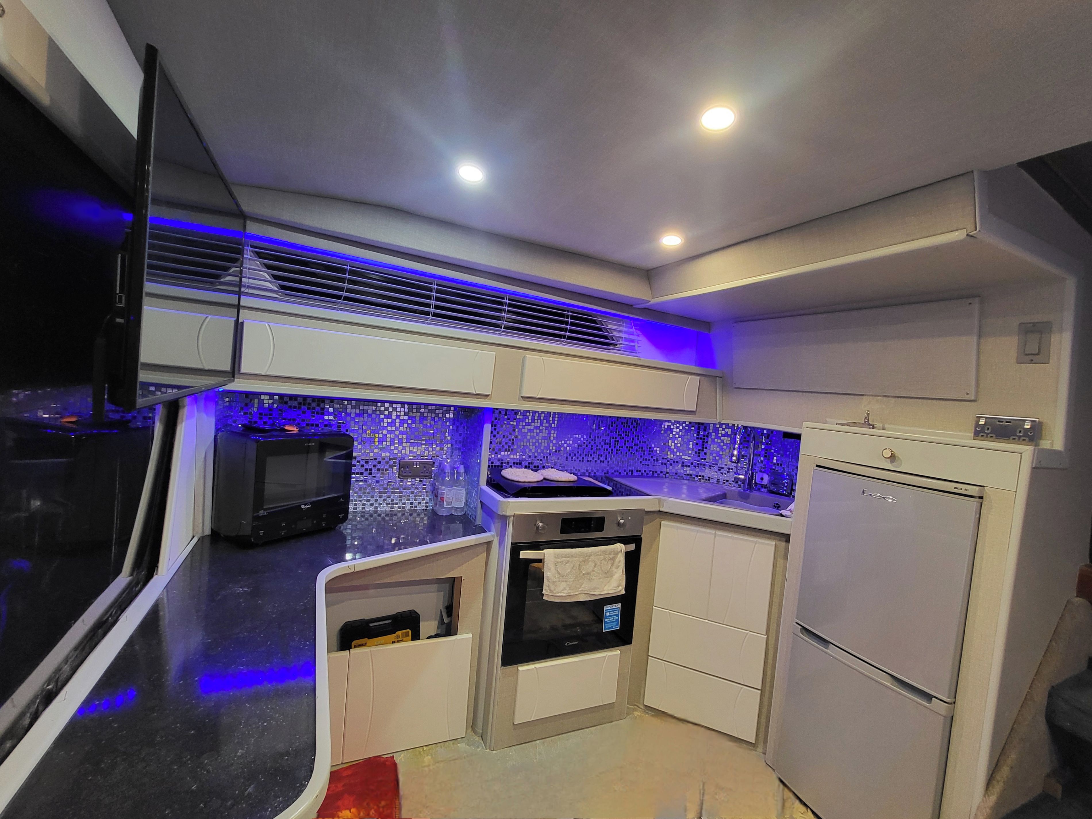 A compact kitchen with a microwave, oven, and refrigerator.