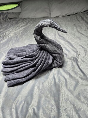 A bed with a swan-shaped towel arrangement.