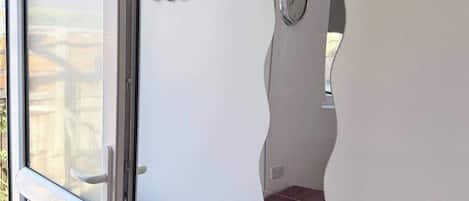 A modern interior with a unique wall design, a clock, and a small brown chest.