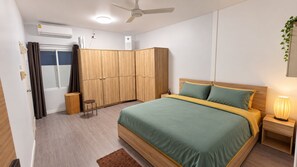 A bedroom with a bed, nightstands, a wardrobe, a ceiling fan, and an air conditioning unit. - Lovely apartment with large kitchen and fantastic terrasse perfectly located (Amphur Muang Satun)
