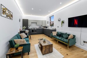 A modern apartment with a living area, kitchen, and dining space. - Apartment Sleeps 7 with Wifi (London)