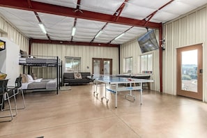 A room with bunk beds, a ping pong table, and a sofa. - Pickleball in Paradise | Sleeps 16, Free Pool Heat, Putting Green, Volleyball, & Games (Paradise Valley)