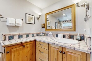 A bathroom with a wooden vanity, a large mirror, and a white sink. - 2BR Ketchum condo with fast WiFi, patio, and easy mountain access. (Ketchum)