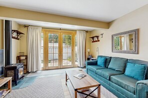 A living room with a sofa, coffee table, and a fireplace. - 2BR Ketchum condo with fast WiFi, patio, and easy mountain access. (Ketchum)