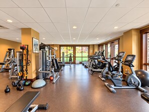 A gym with cardio machines, weight training equipment, and a view of the outdoors. - Trailhead Lodge #5116 condo with fireplace, under three miles from downtown (Steamboat Springs)