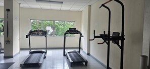 Ein Fitnessraum mit Laufbändern, einem Ergometer und einer Klimmzugstange.