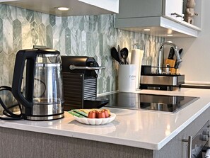 Een moderne keuken met een koffiezetapparaat, een broodrooster en een schaal met toevoegingen.