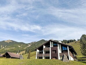 A chalet-style building with a balcony, set against a mountainous backdrop. - Mountain View Lodge by Interhome (Sörenberg)
