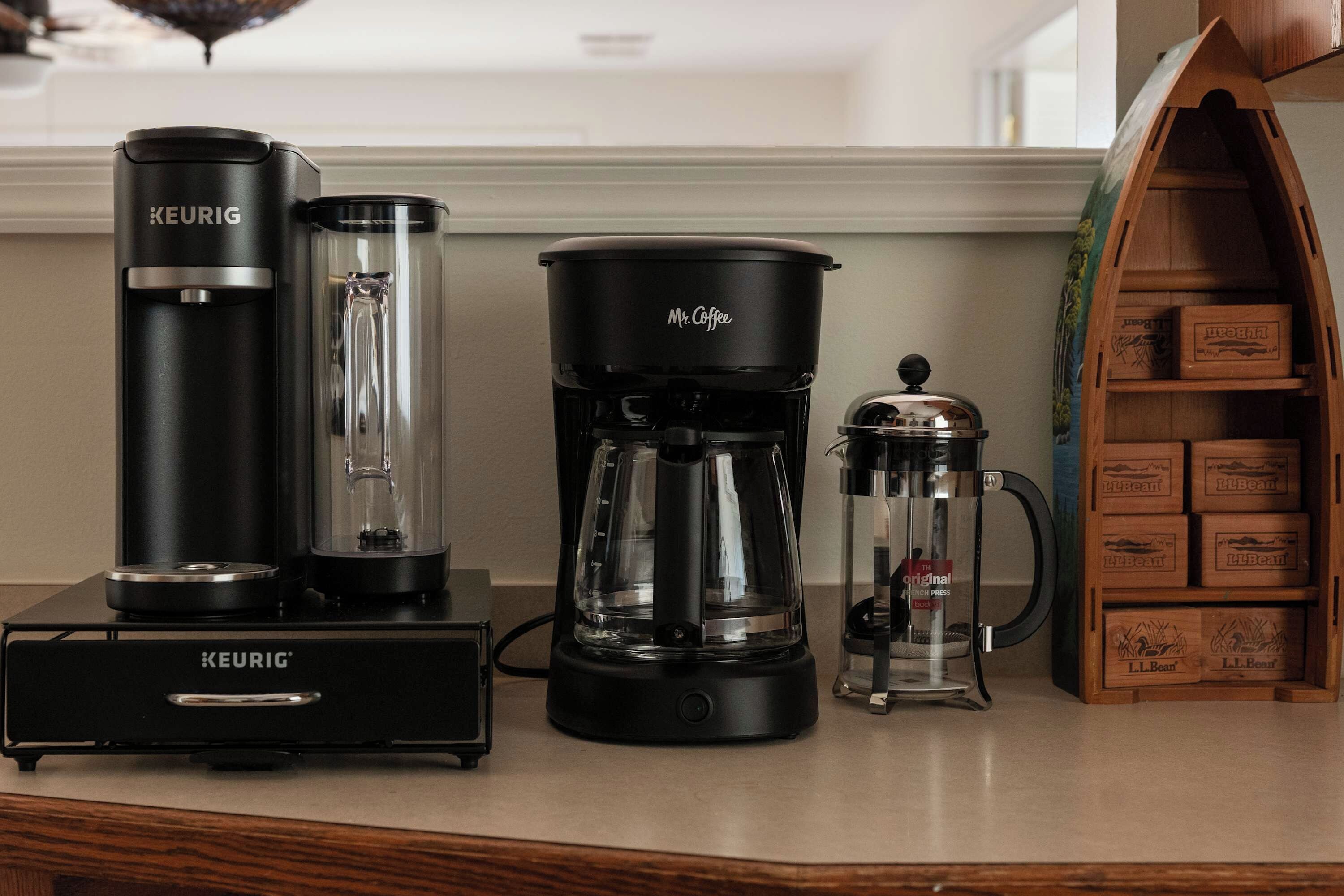 Una cafetera, una Keurig y una jarra de café sobre una encimera de cocina.