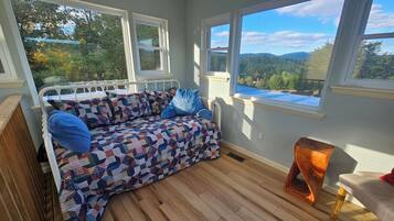 A cozy room with a bed, a window, and a view of the outdoors.
