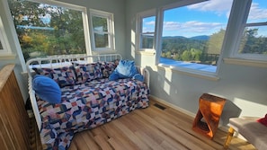 A cozy room with a bed, a window, and a view of the outdoors.