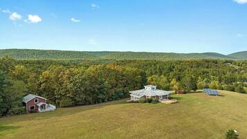 A rural property with two main buildings, a barn, and a house with solar panels.