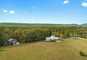 A rural property with two main buildings, a barn, and a house with solar panels.